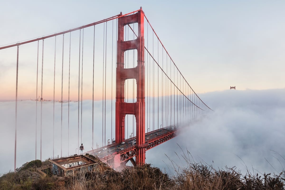 Golden Gate Bridge covered in clouds with SF in the background | Hotel Focus