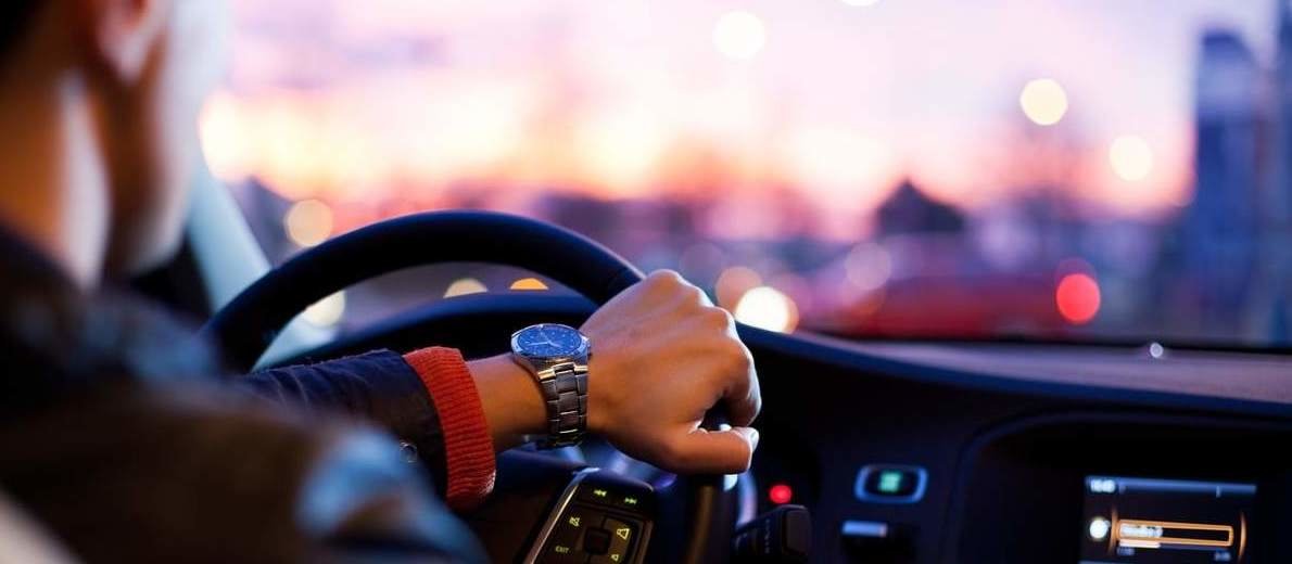 Man wearing a watch and driving a car